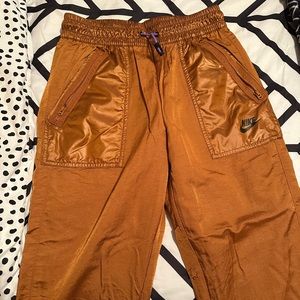 Orangish/brown/gold Nike track pants